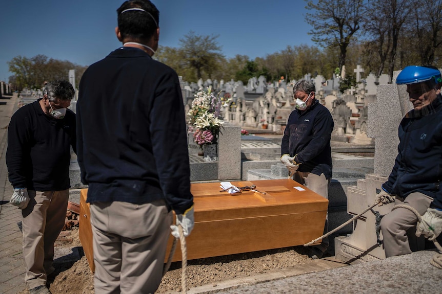 People bury an elderly COVID-19 victim in Spain.