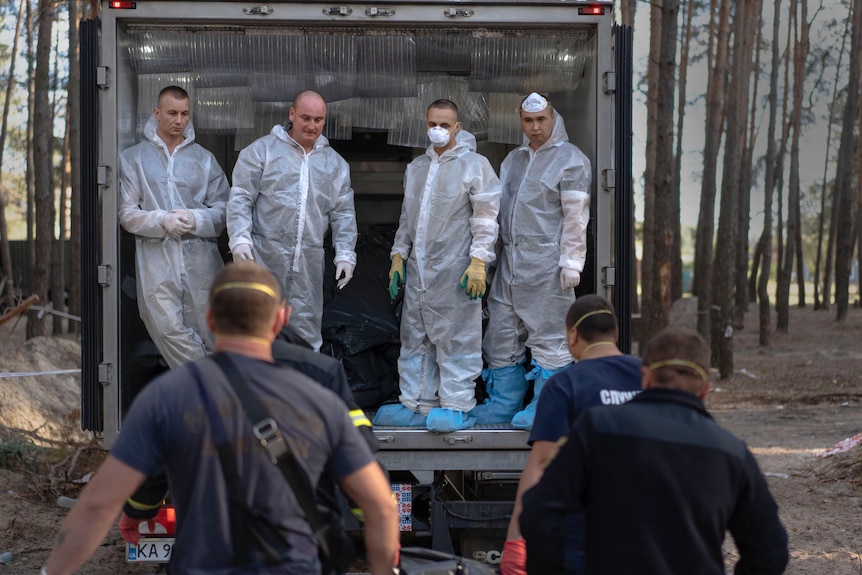 A body is loaded into a truck.