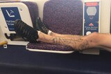 A man's feet on the seat of a train