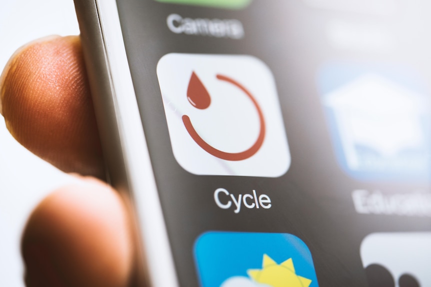 A close up of a smartphone screen with an app names 'cycle' with a red circle and red drop of blood.