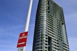 no stopping sign with an apartment building in the backgournd