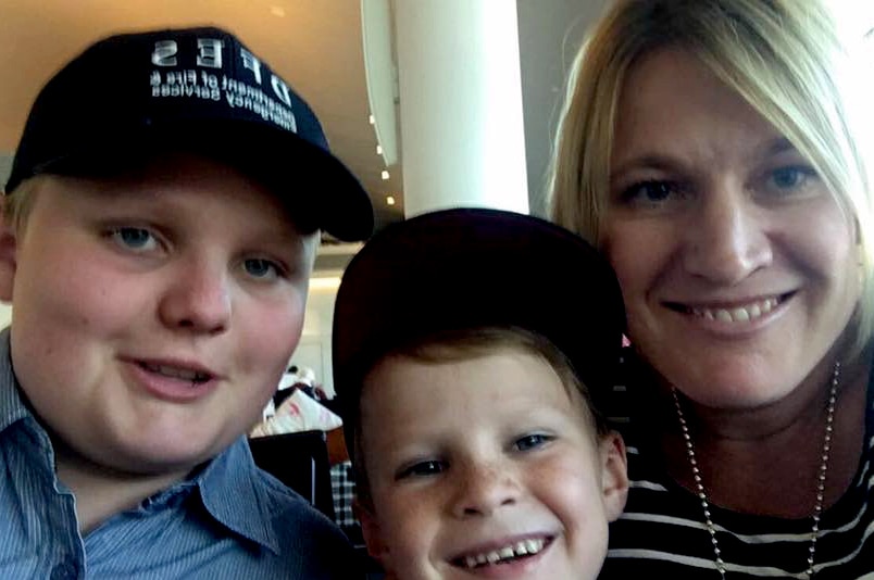 A selfie of woman and two boys wearing baseball caps