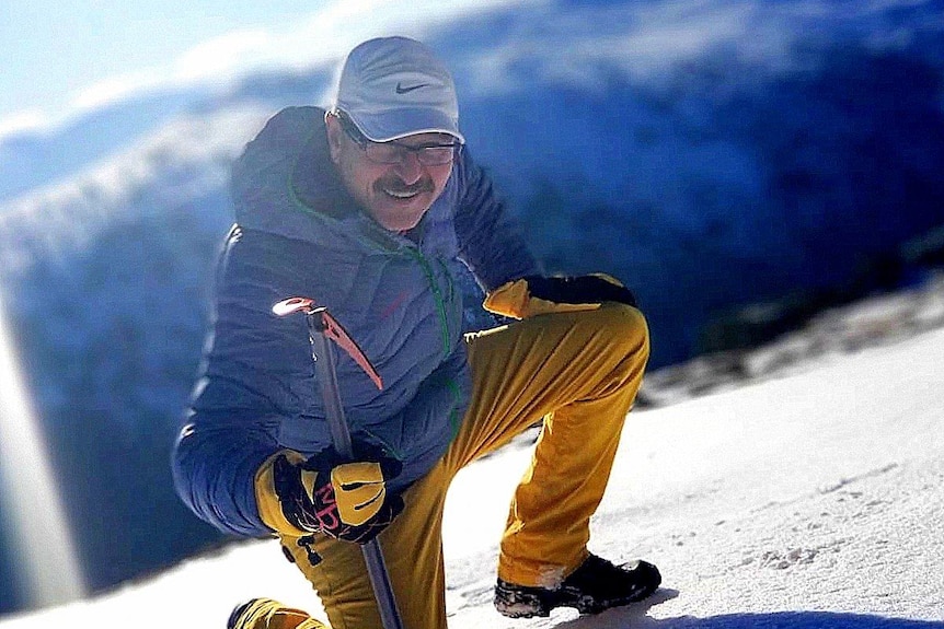 Bayram Cini holds a climbing pick on a snow covered mountain.
