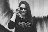 Nicola Thorp wears a shirt with the word "Feminism" on it.
