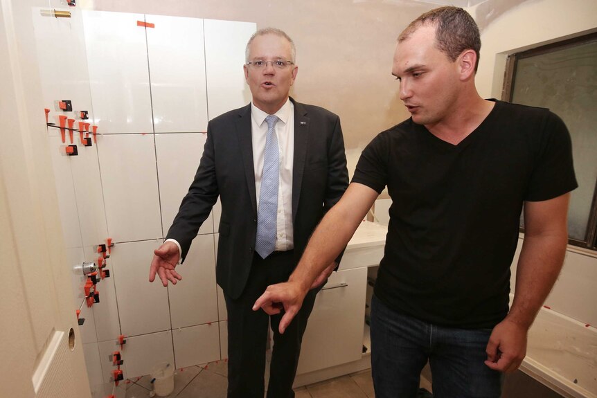 Scott Morrison and a man look in a renovated bathroom.