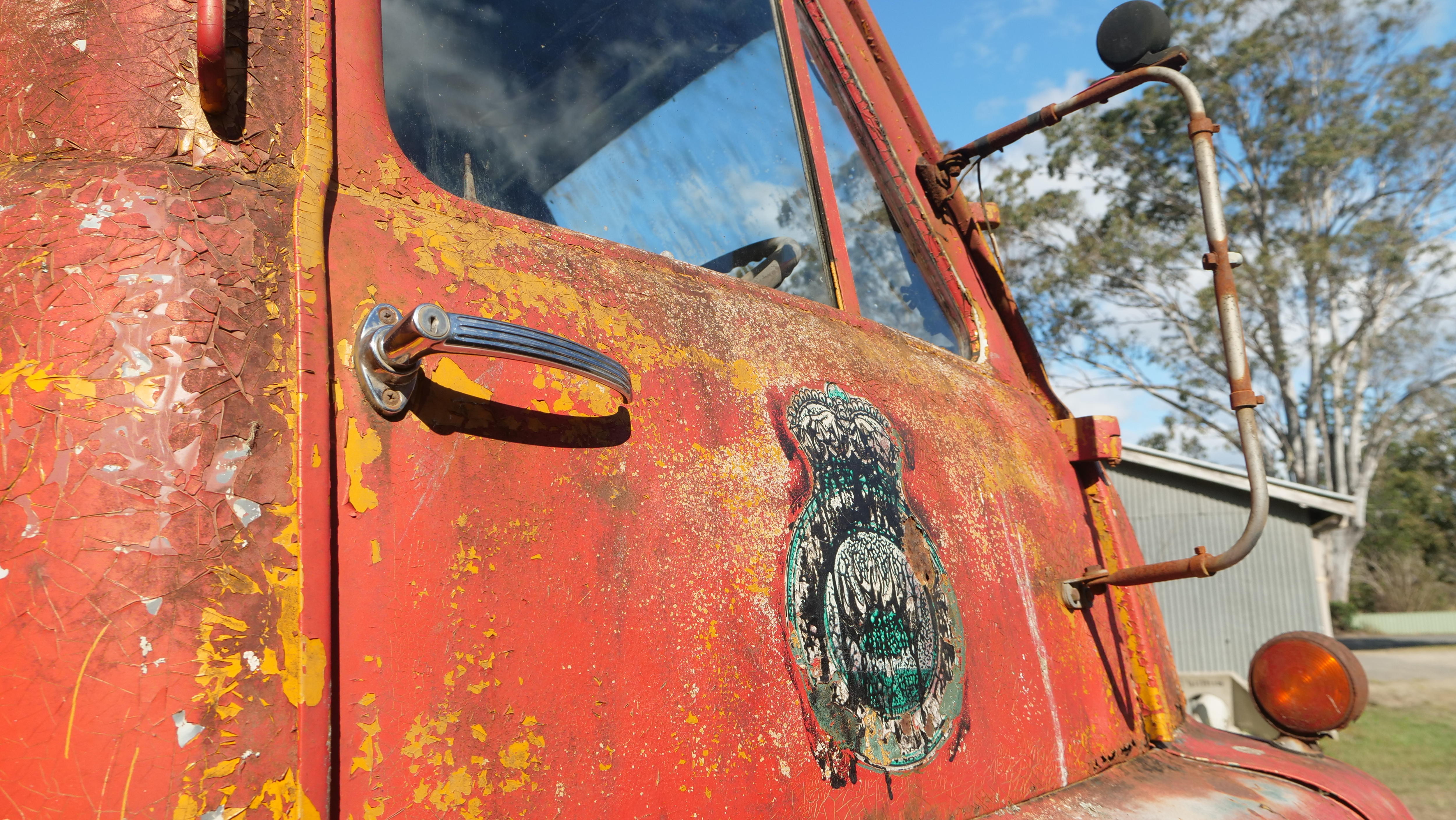 A rusty sign saying Bellbrook on the side of an old truck.