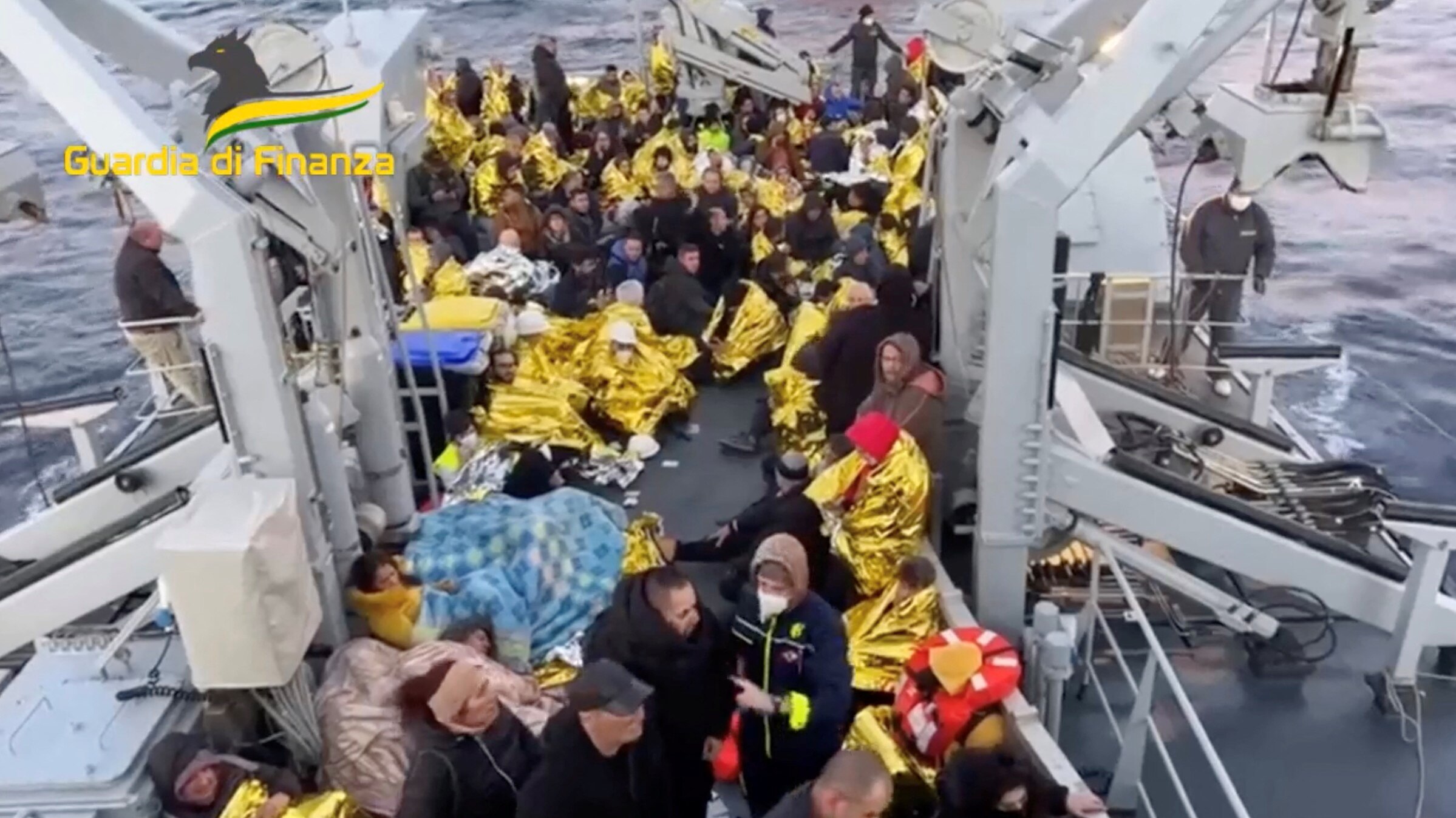 Rescued passengers huddled together aboard an Italian rescue ship.