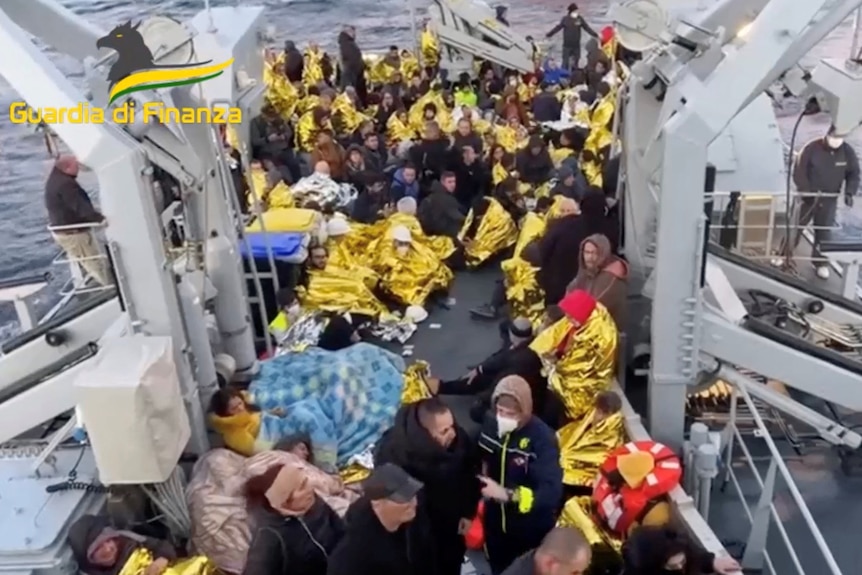 I passeggeri soccorsi si radunano su una nave di soccorso italiana.