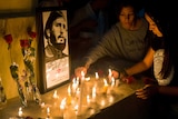 Students place candles and roses around an image of the late Cuban leader Fidel Castro.