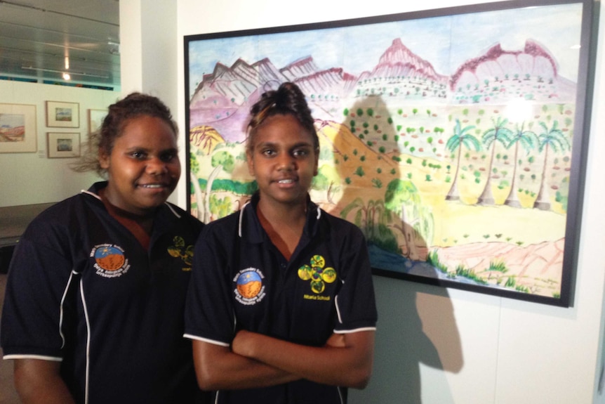 Ntaria School students stand in front of their artwork - Tjurretja (West MacDonnell Ranges).