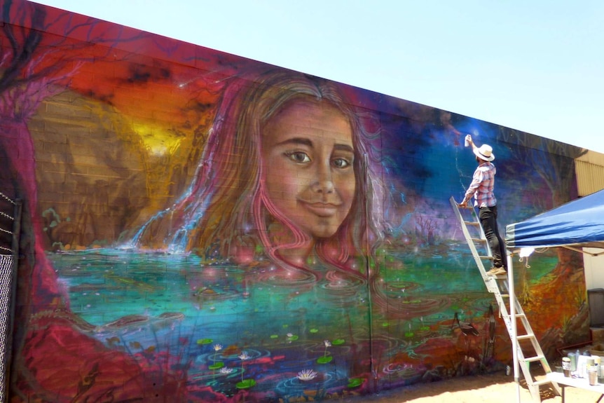 A mural of an 11-year-old girl on the side of a building