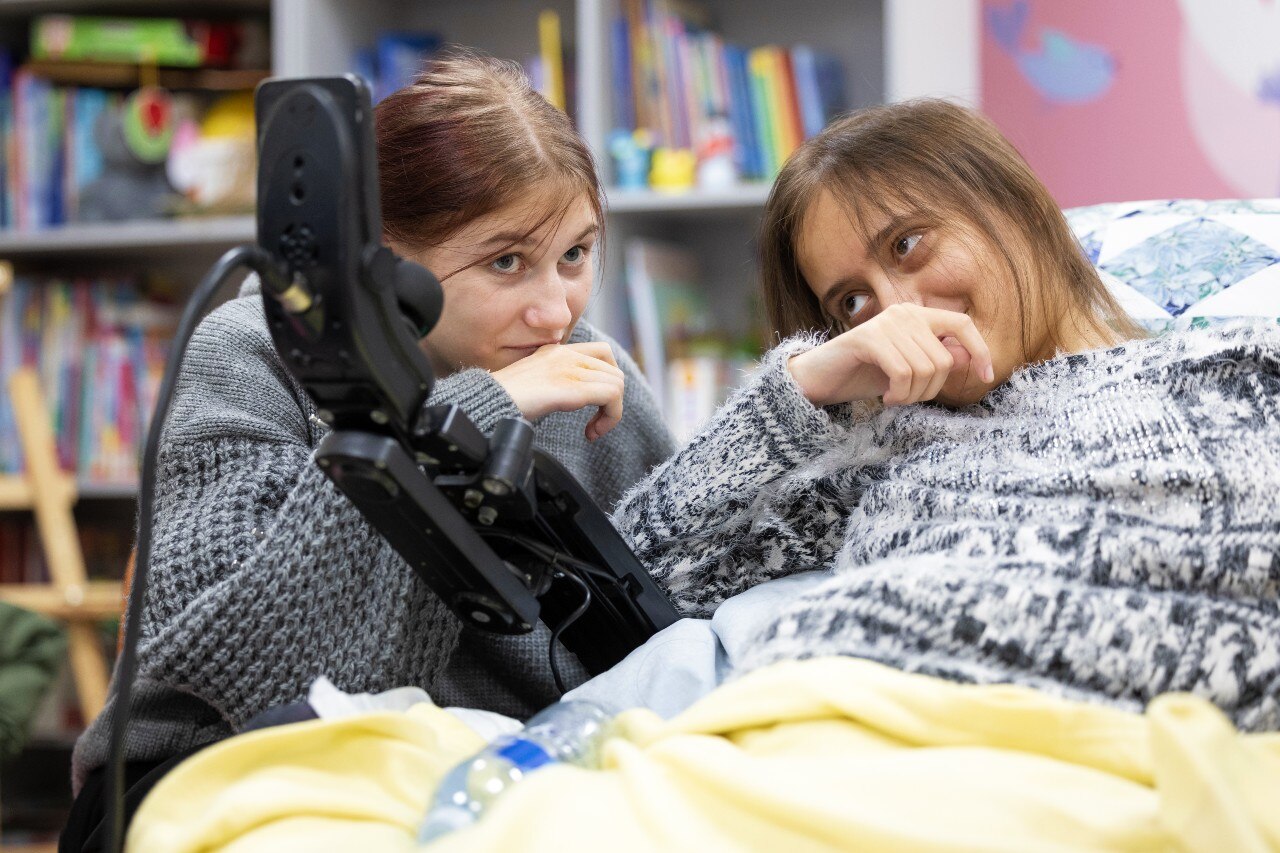 Two young girls smiling at each other.