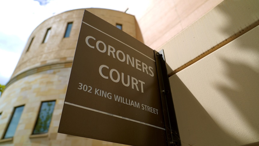 A sign saying CORONERS COURT on a modern sandstone building