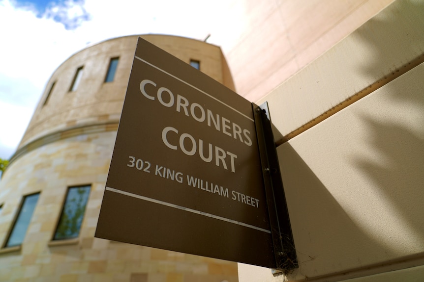 A sign saying CORONERS COURT on a modern sandstone building