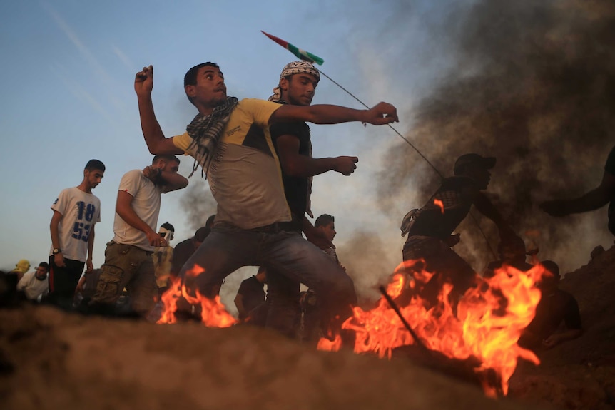 Palestinian protestors throw stones at Israeli soldiers
