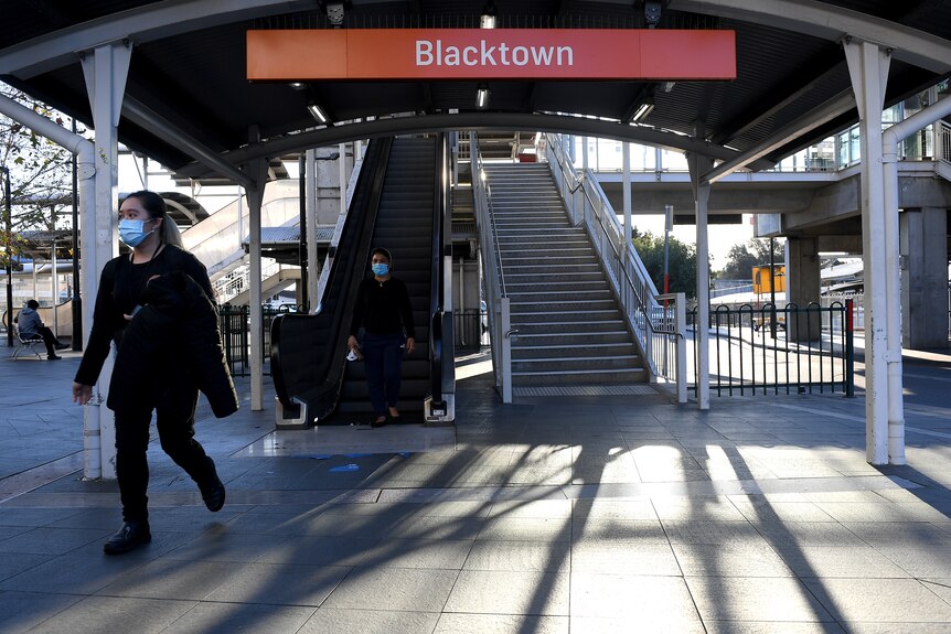 Just two people arrive on the Blacktown railway station platform. Both are wearing surgical masks.