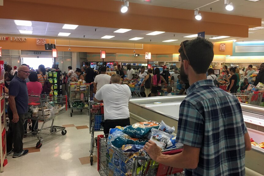 ABC cameraman brad pushes a trolley loaded with food in a supermarket in Miami.