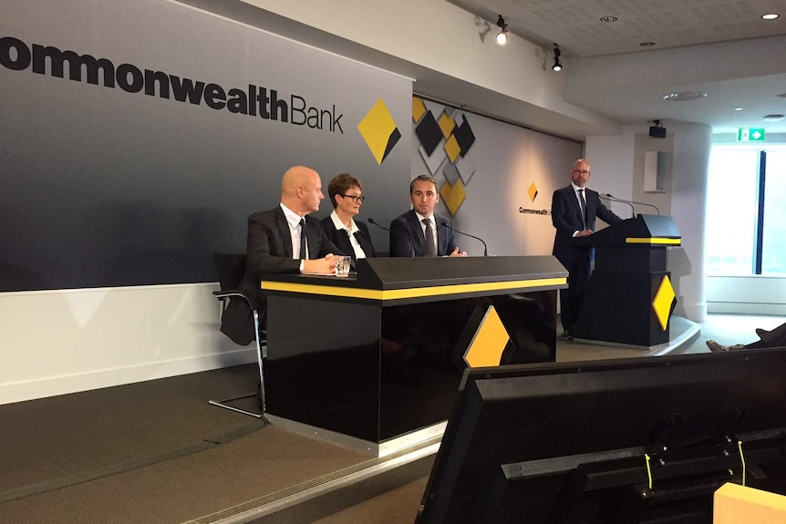 Commonwealth Bank top brass Matt Comyn, Catherine Livingstone and Ian Narev sit at CBA-branded desk for a media conference