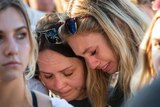 Women embrace during a prayer vigil