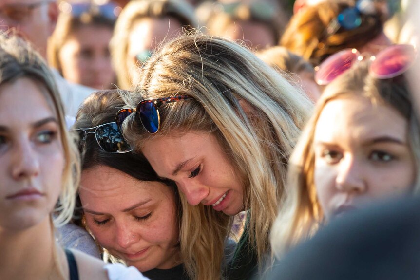 Women embrace during a prayer vigil