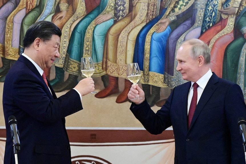 Vladimir Putin and Xi Jinping look at each other and raise glasses in front of a painting.
