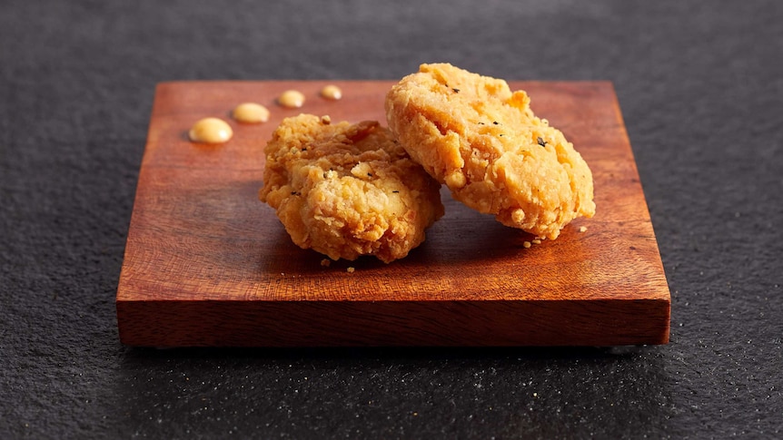 A pair of nuggets on a wooden board.