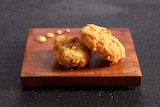 A pair of nuggets on a wooden board.