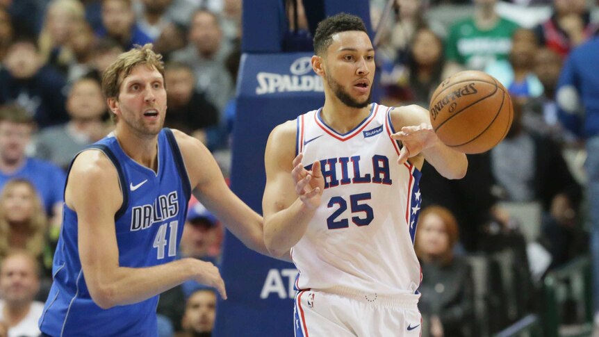 Ben Simmons passes the ball for the 76ers as Dirk Nowitzki watches on.