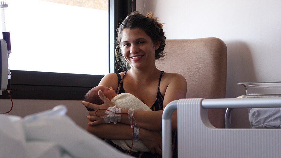 A woman holding a newborn baby