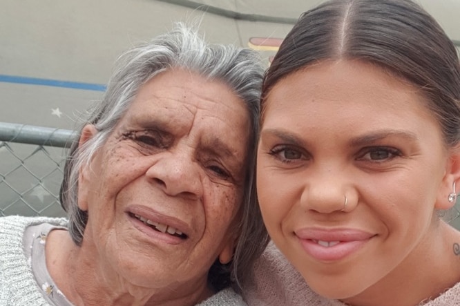 Natarsha Bamblett hugs her grandmother as they both smile together.