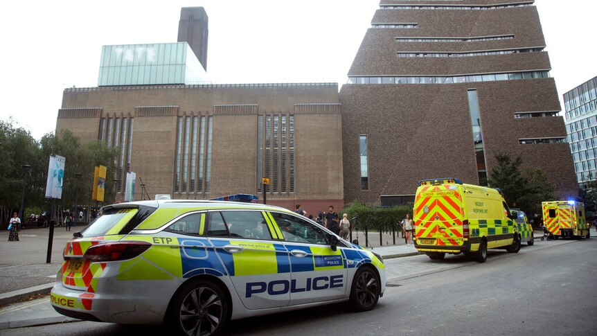 Police vehicles are parked in front of the Tate Modern art gallery in London