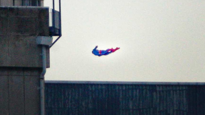 A superman drone is seen flying over the power plant walls