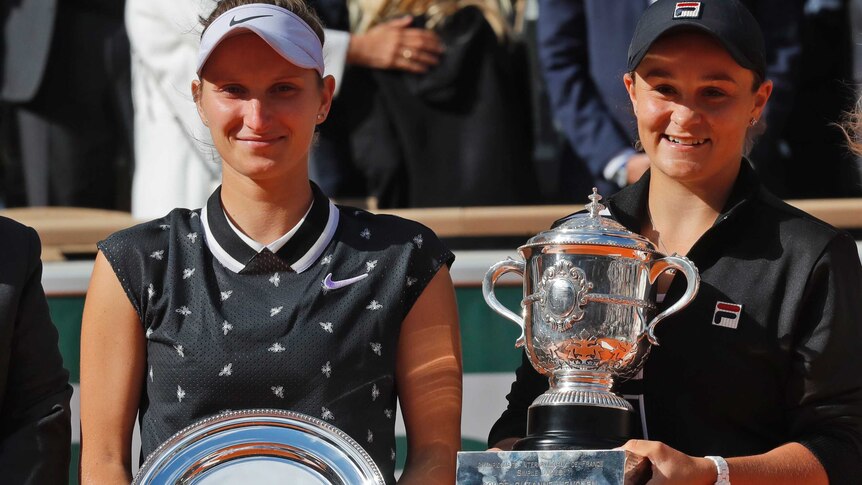 Ashleigh Barty, right, holds A trophy and Marketa Vondrousova stands beside her holding a silver plate as runner up