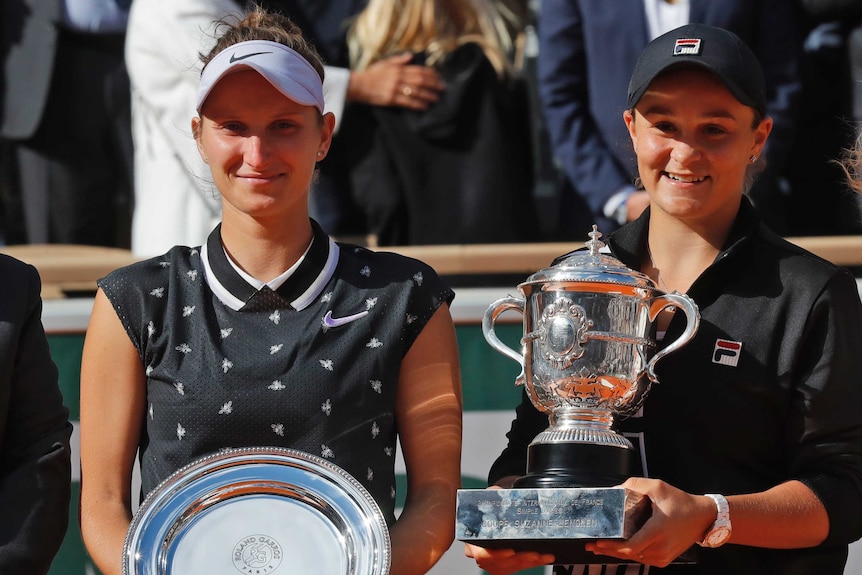 Ashleigh Barty, right, holds A trophy and Marketa Vondrousova stands beside her holding a silver plate as runner up
