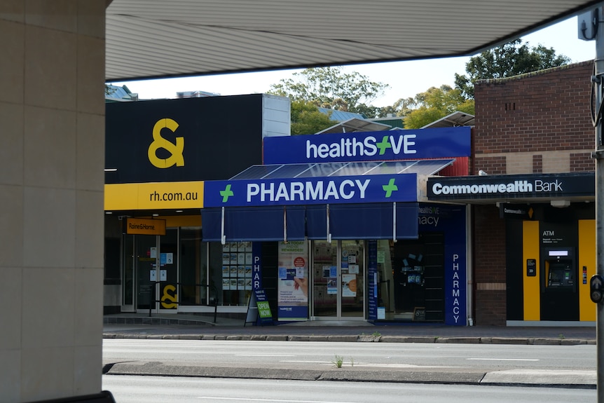 A pharmacy shop front along a deserted main street.