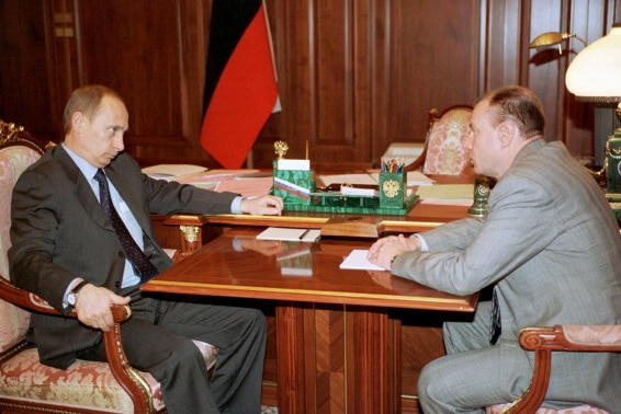 One of Russia's richest men, Vladimir Potanin, sits across from Vladimir Putin in 2002.