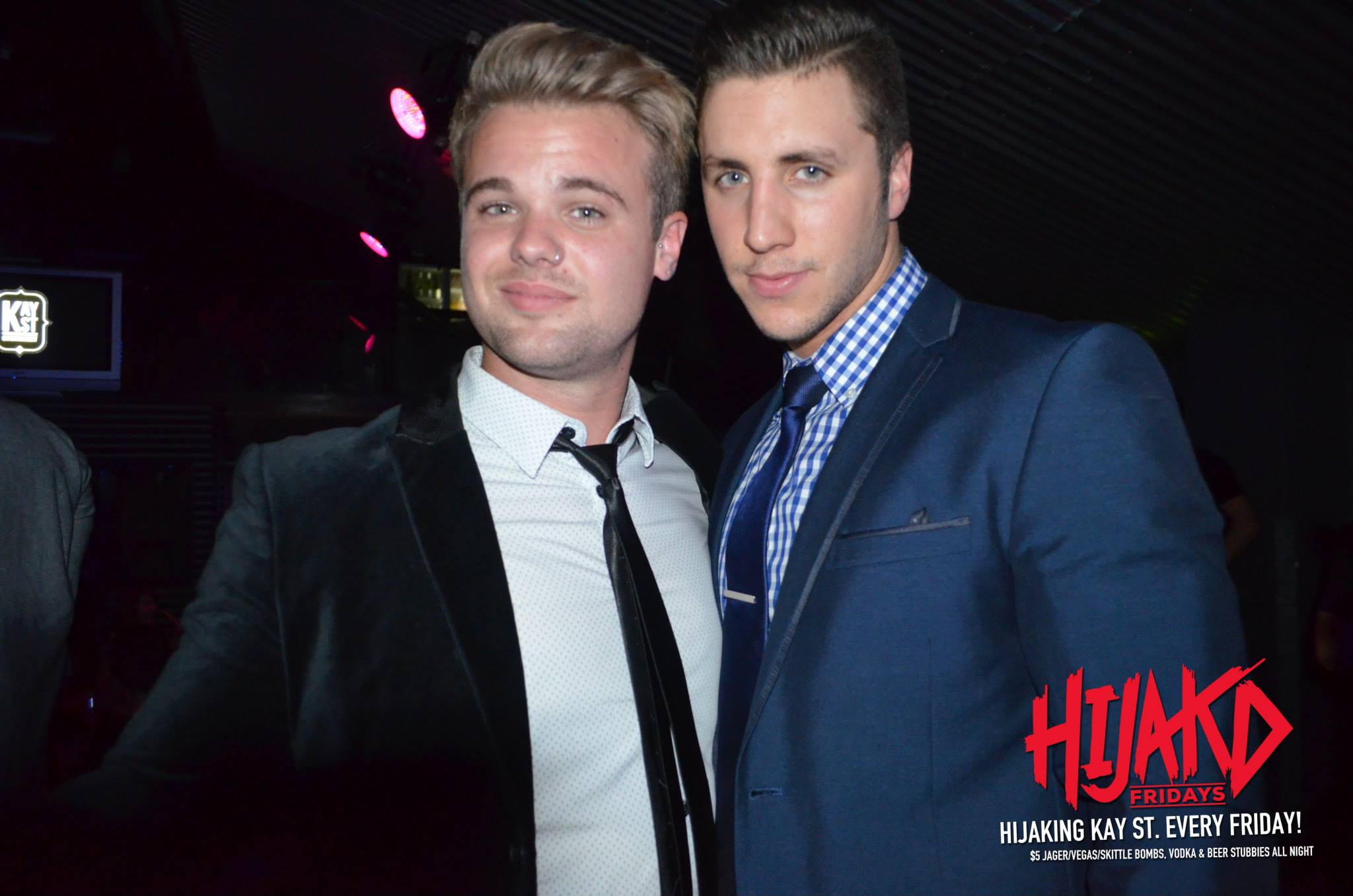 Two men in suits pose for a photo.