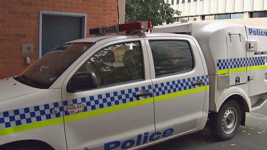A police van takes Jassy and Michael Anglin into the Hobart police station after their extradition from Queensland.