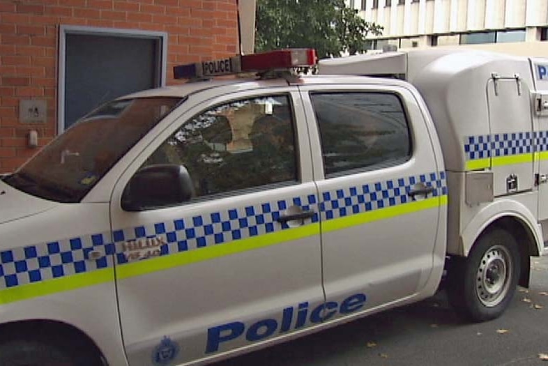 A police van takes Jassy and Michael Anglin into the Hobart police station after their extradition from Queensland.