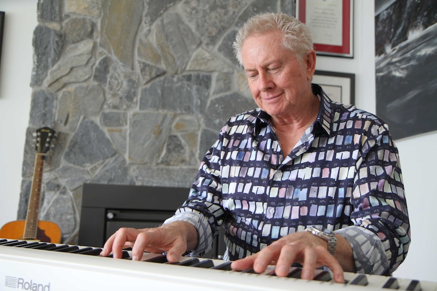 Stephen Baker playing the piano in his home