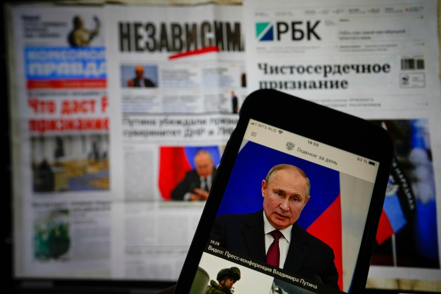 L'application du journal gouvernemental russe s'affiche sur un écran d'iPhone avec des journaux en arrière-plan.