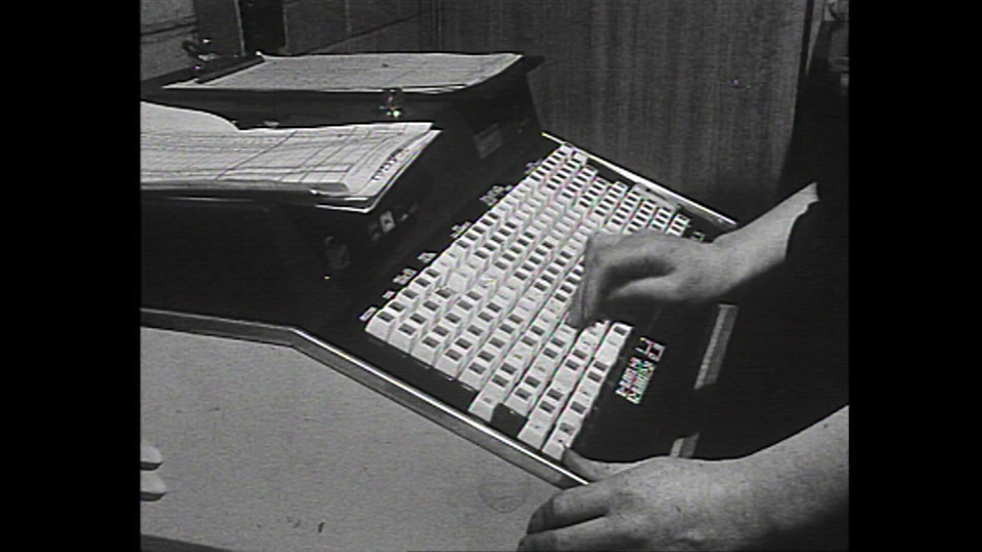 A black and white close up image of a large keyboard-style computer from 168 