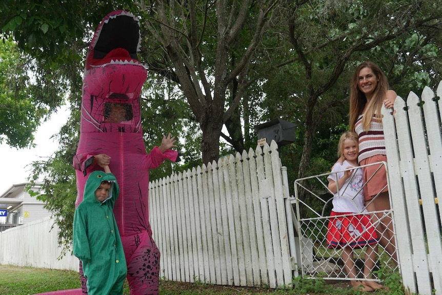 Lou Bromley and her son four-year-old Angus Love, dressed in dinosaur costumes, meet their neighbours.