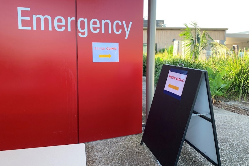 A red wall with 'Emergency' and a sign saying 'Fever clinic'