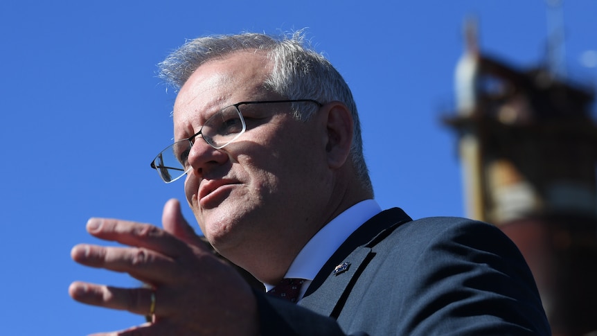 Close up of Scott Morrison talking and raising his hand.