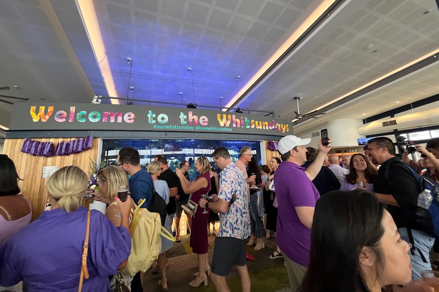 People gather in room under Whitsundays sign