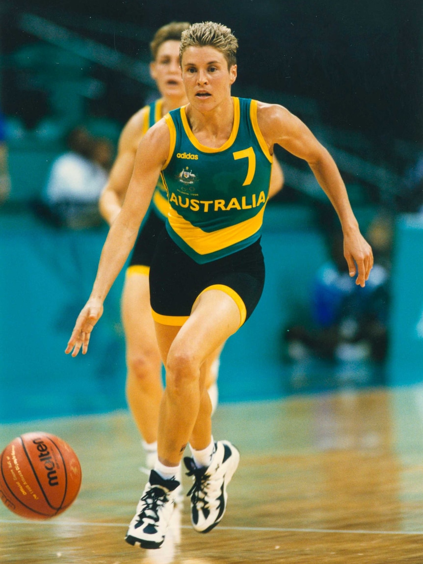 Michele Timms bounces a basketball on court.