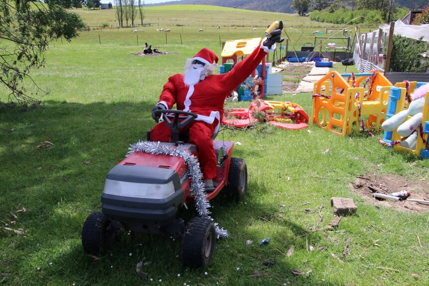 A stuffed Santa sits atop a ride-on lawn mower in the Tasmanian town of Lilydale.
