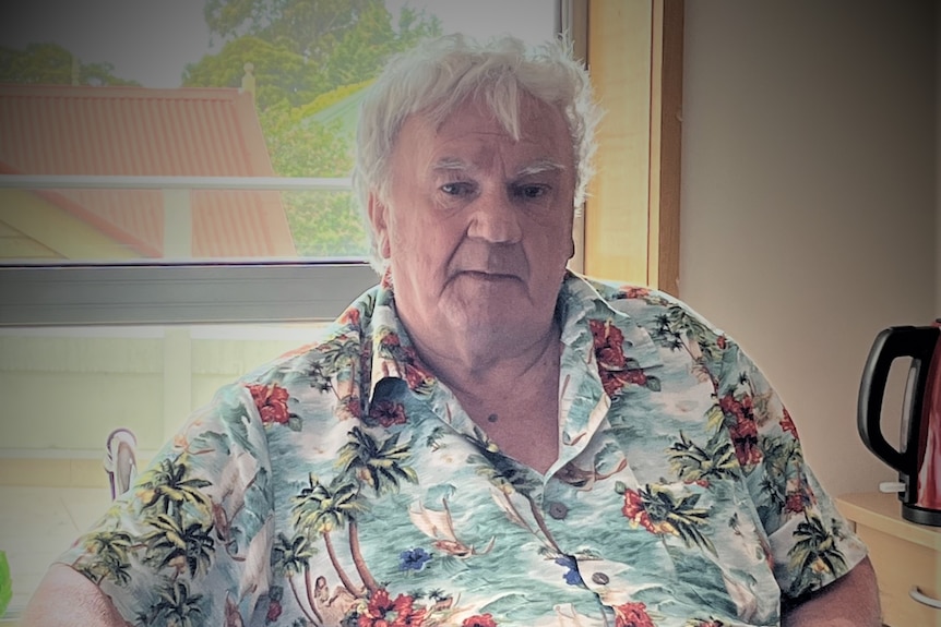 A man sitting in a wheelchair in his room at a nursing home.