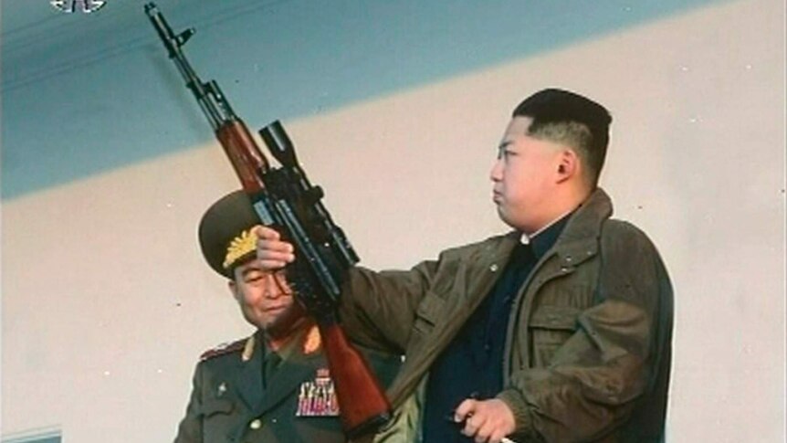 An image of Kim Jong-un holding a rifle.